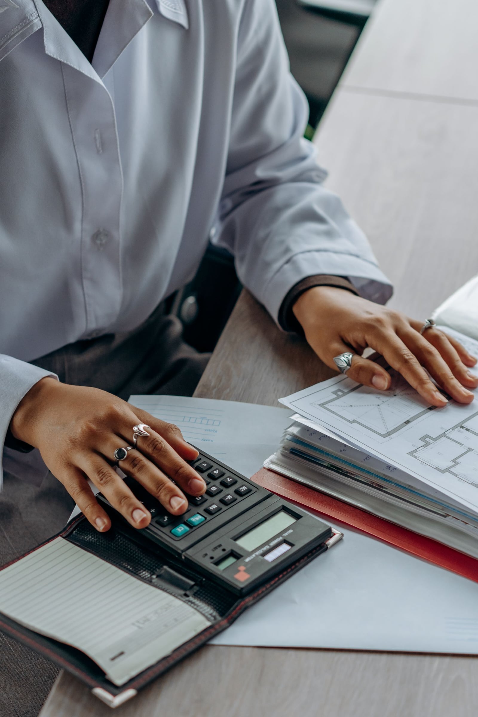 Person reviewing paperwork and calculating a roof replacement budget