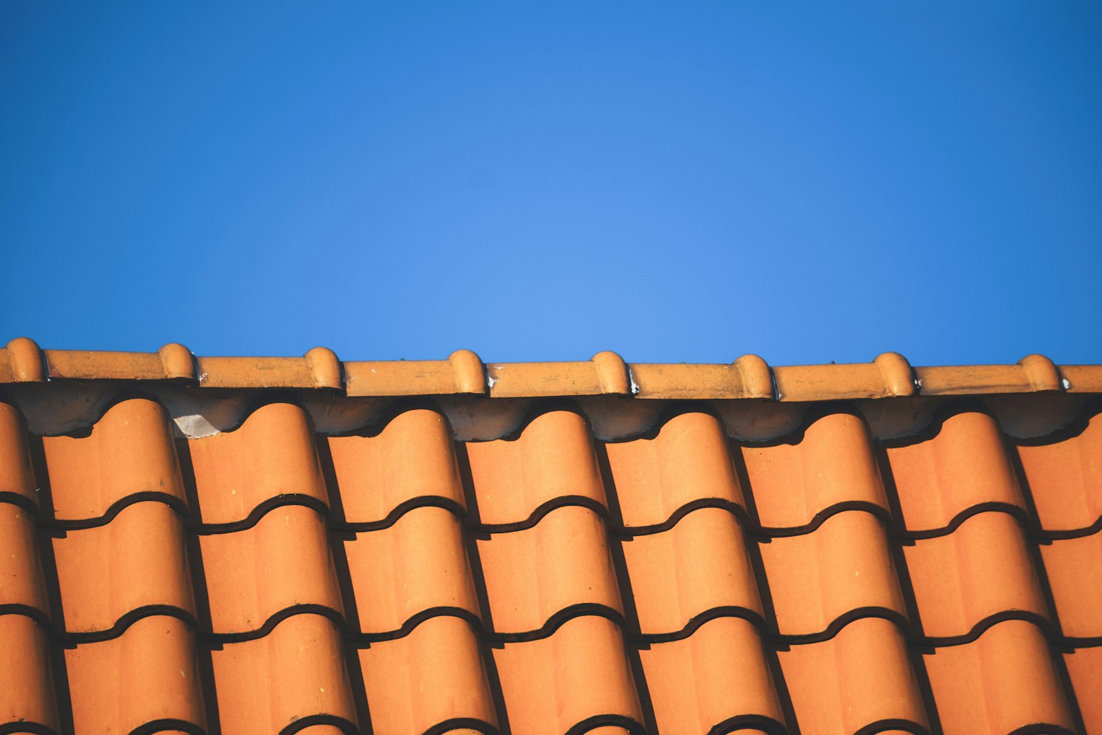 Tile roof repair Huntington Beach — clay tile roof against blue sky