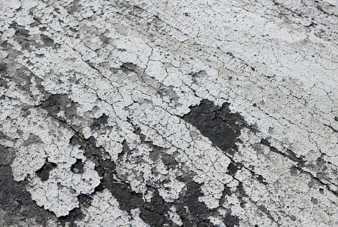 Cracked and chalking roof coating showing signs of failure from UV exposure
