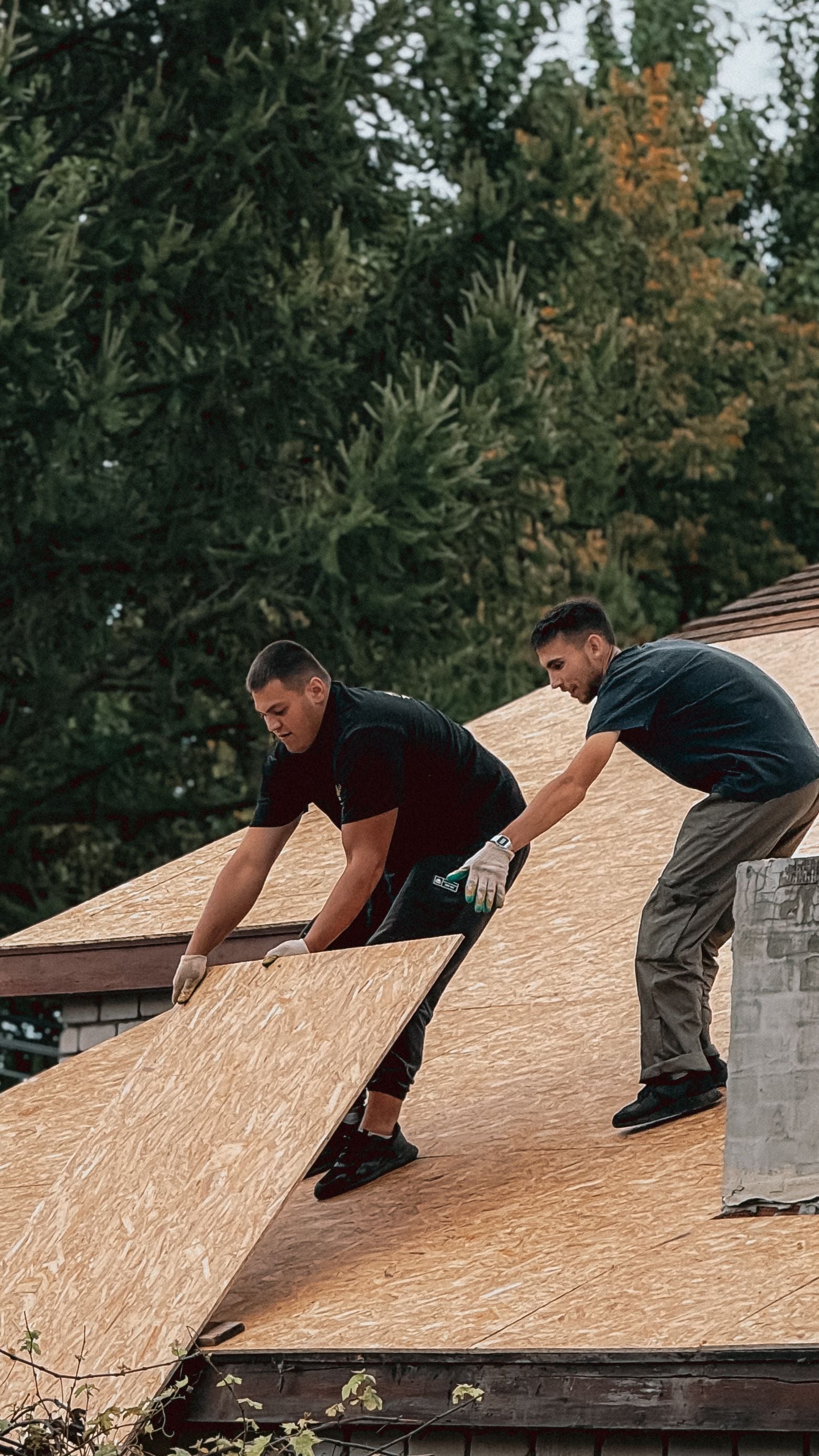 Workers on exposed roof decking during a re-roof