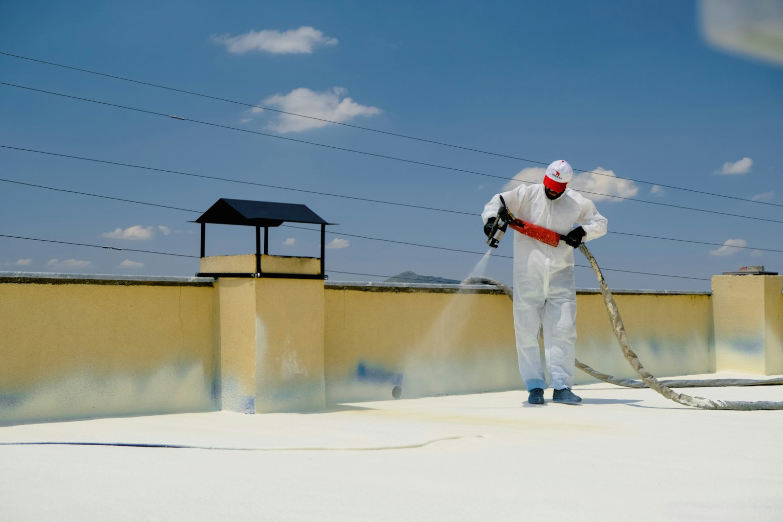 Flat roof repair Huntington Beach — worker applying a waterproof coating