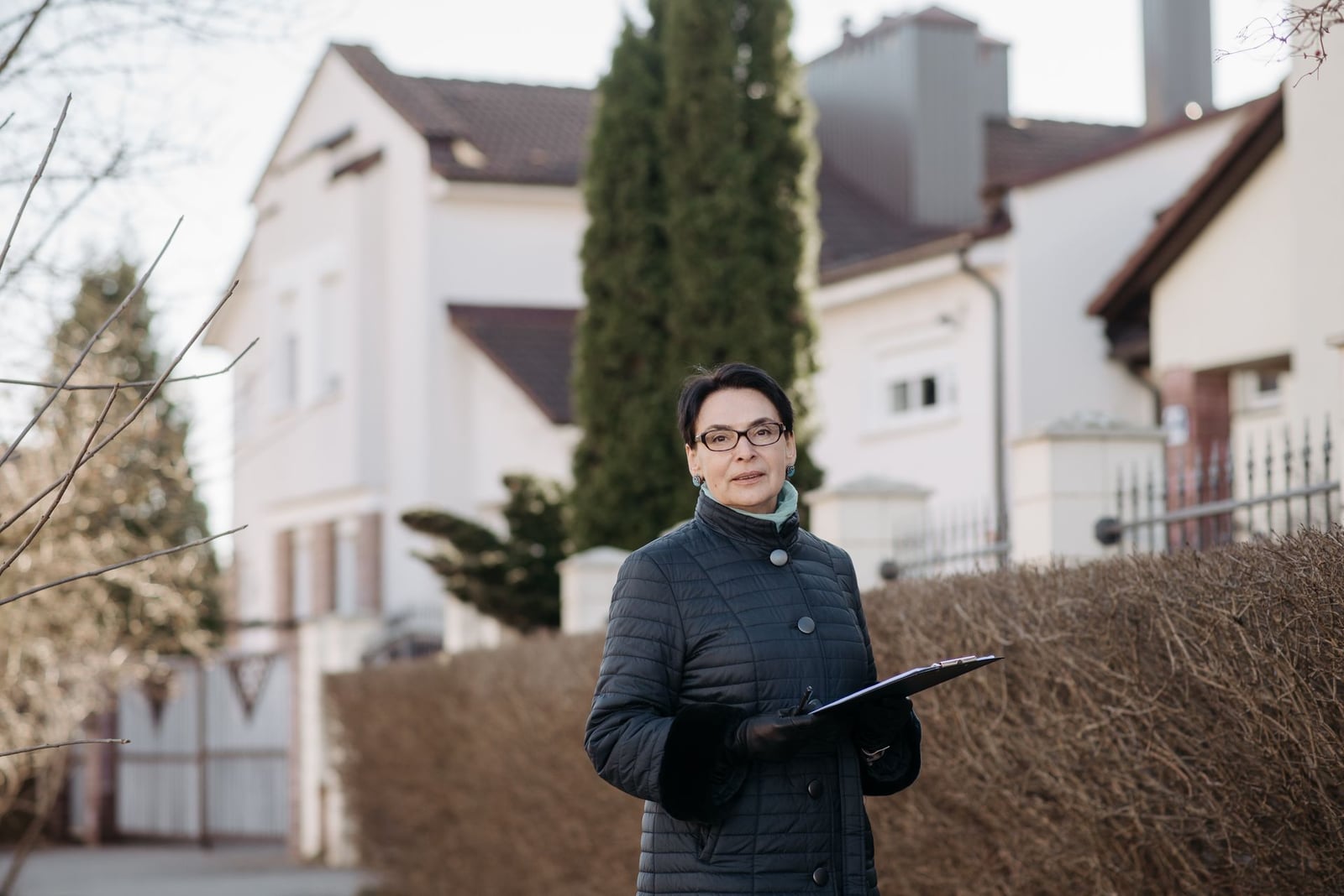 Inspector with a clipboard outside a house exterior