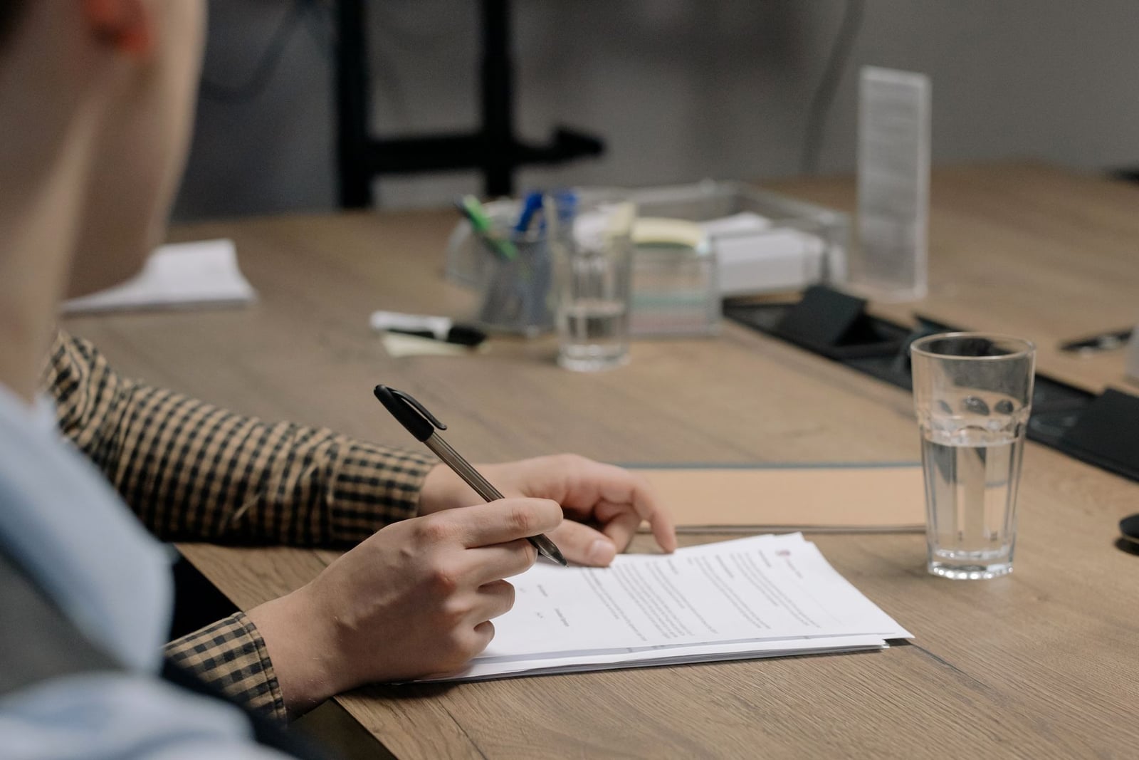 Person signing a roofing contract document