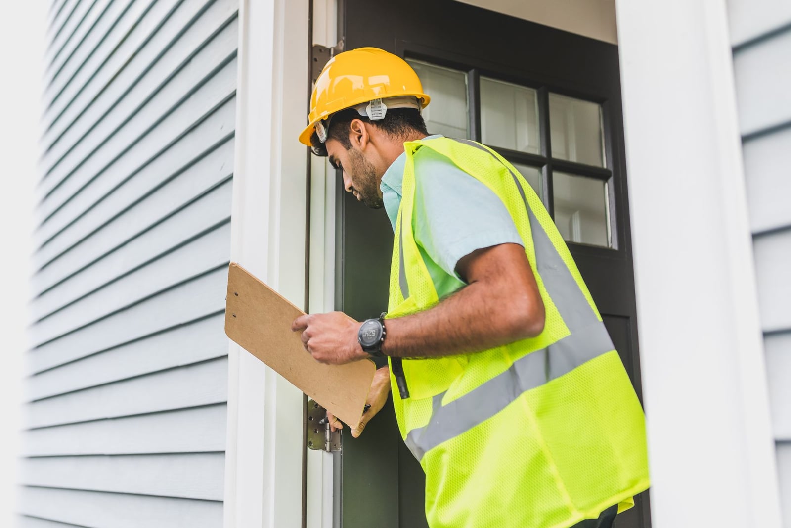 Inspector reviewing a property with a clipboard before listing