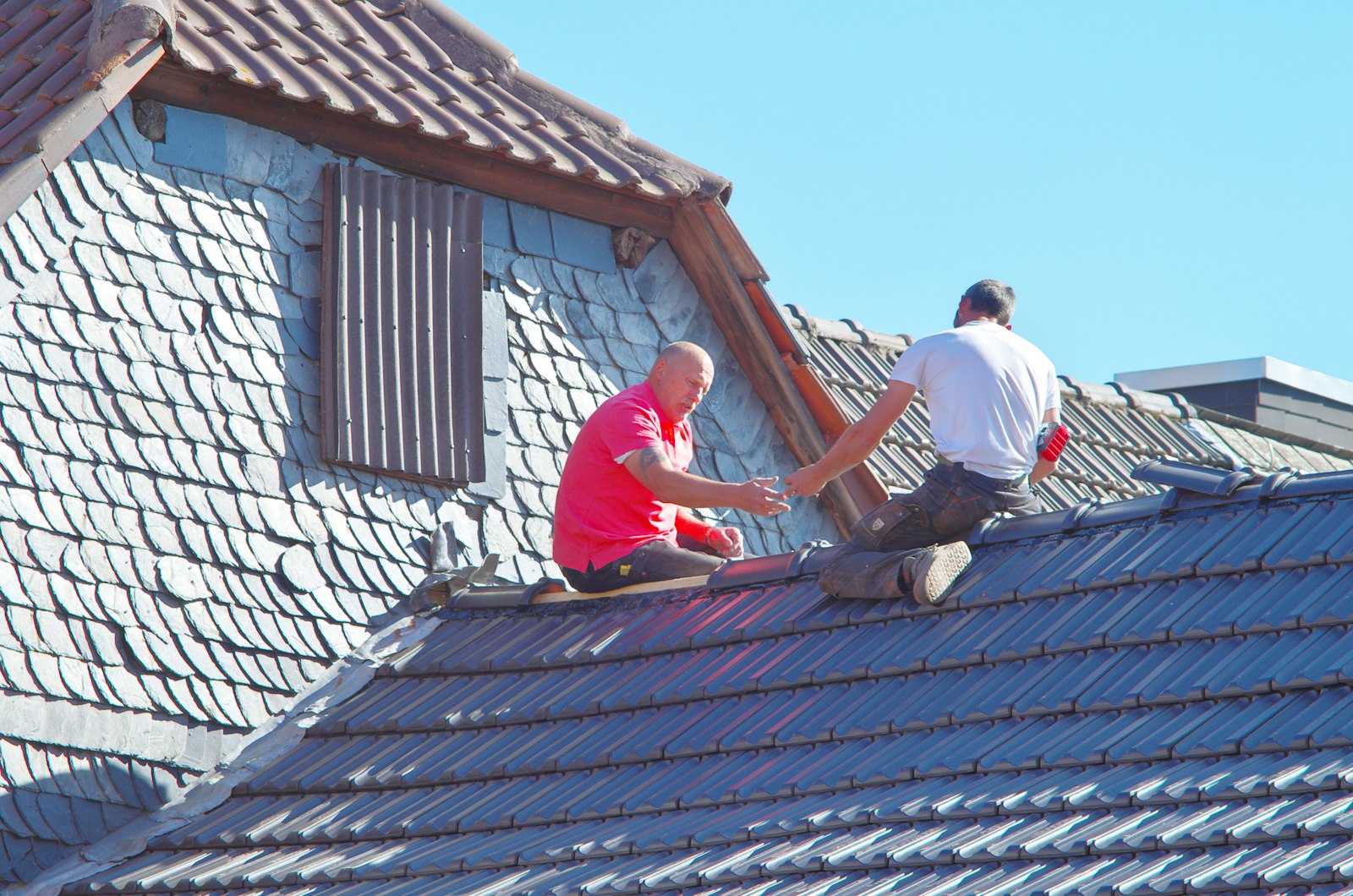 Roofing crew replacing a full section of a residential roof in Huntington Beach