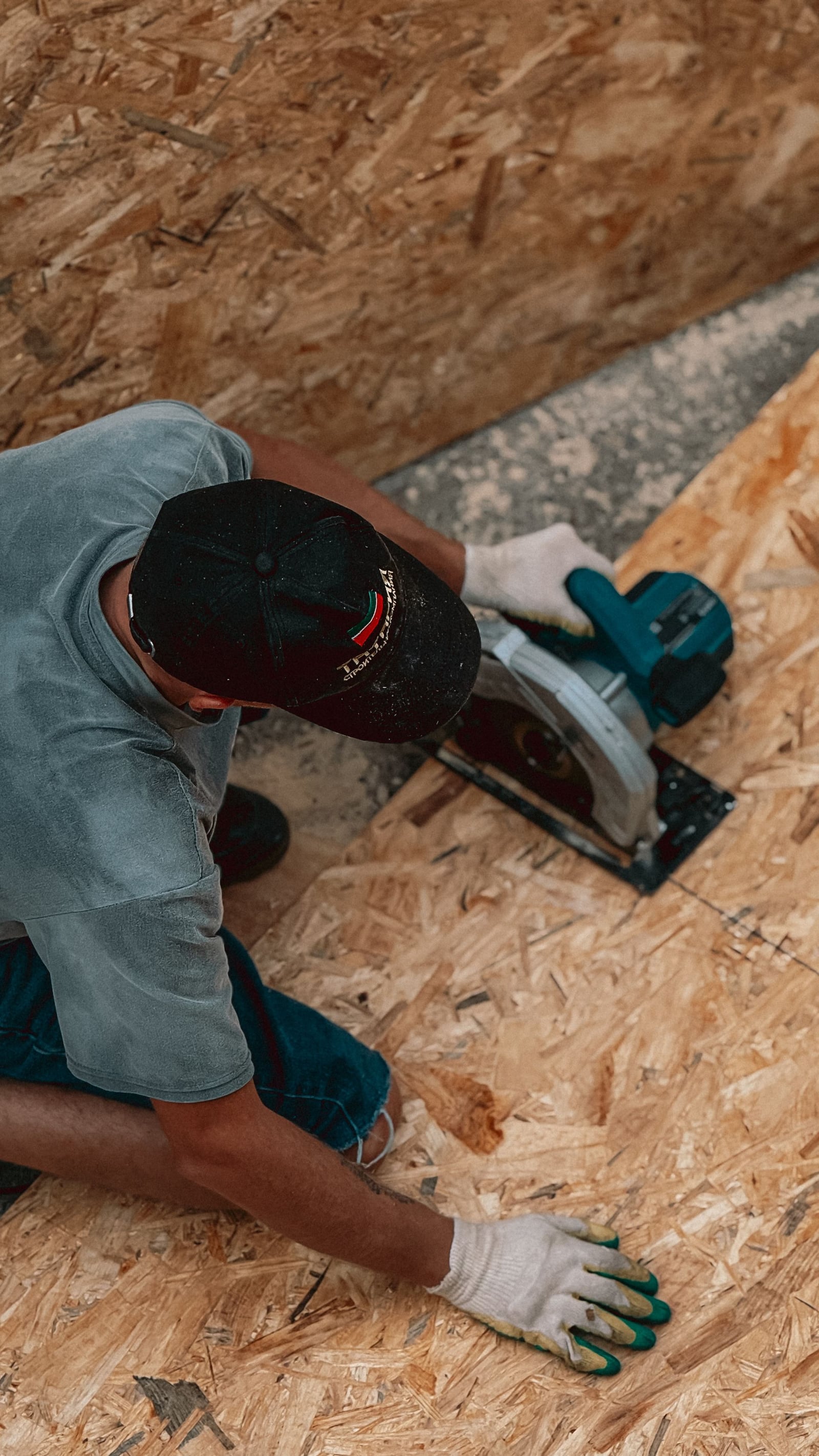Roofer cutting a plywood decking sheet for replacement