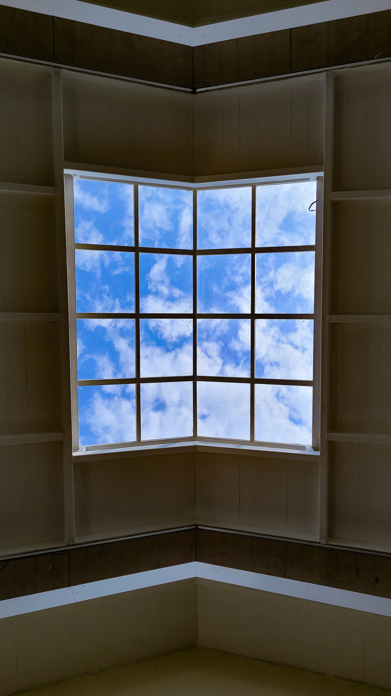 Interior view looking up through a skylight to blue sky