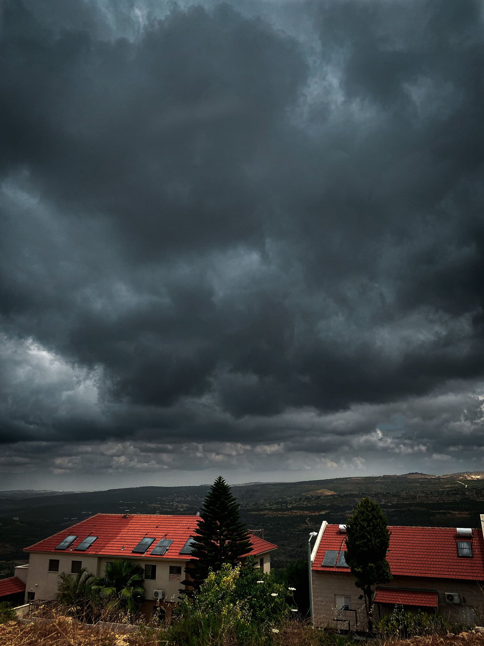 Storm clouds gathering over a neighborhood of rooftops