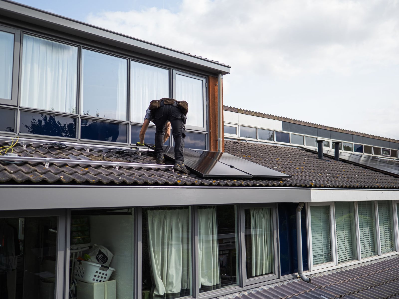 Technician installing solar panels on a rooftop