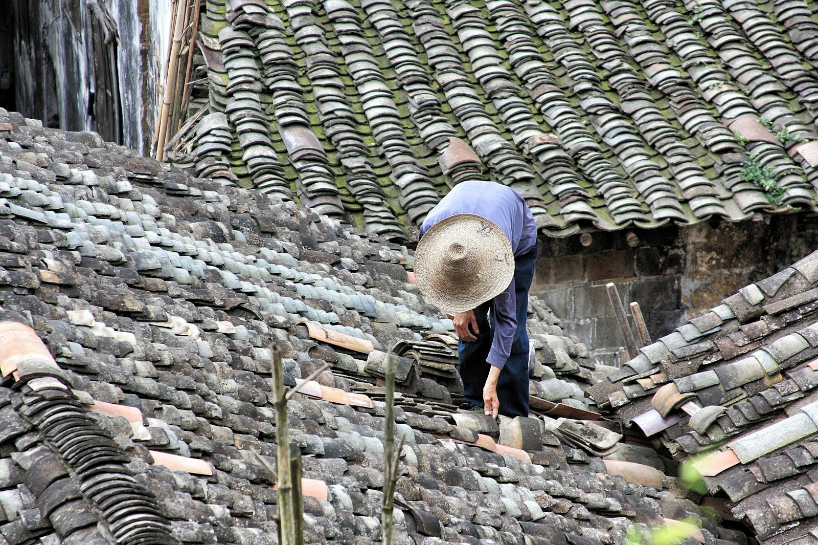 Tile roof repair Huntington Beach — worker standing on a clay tile roof