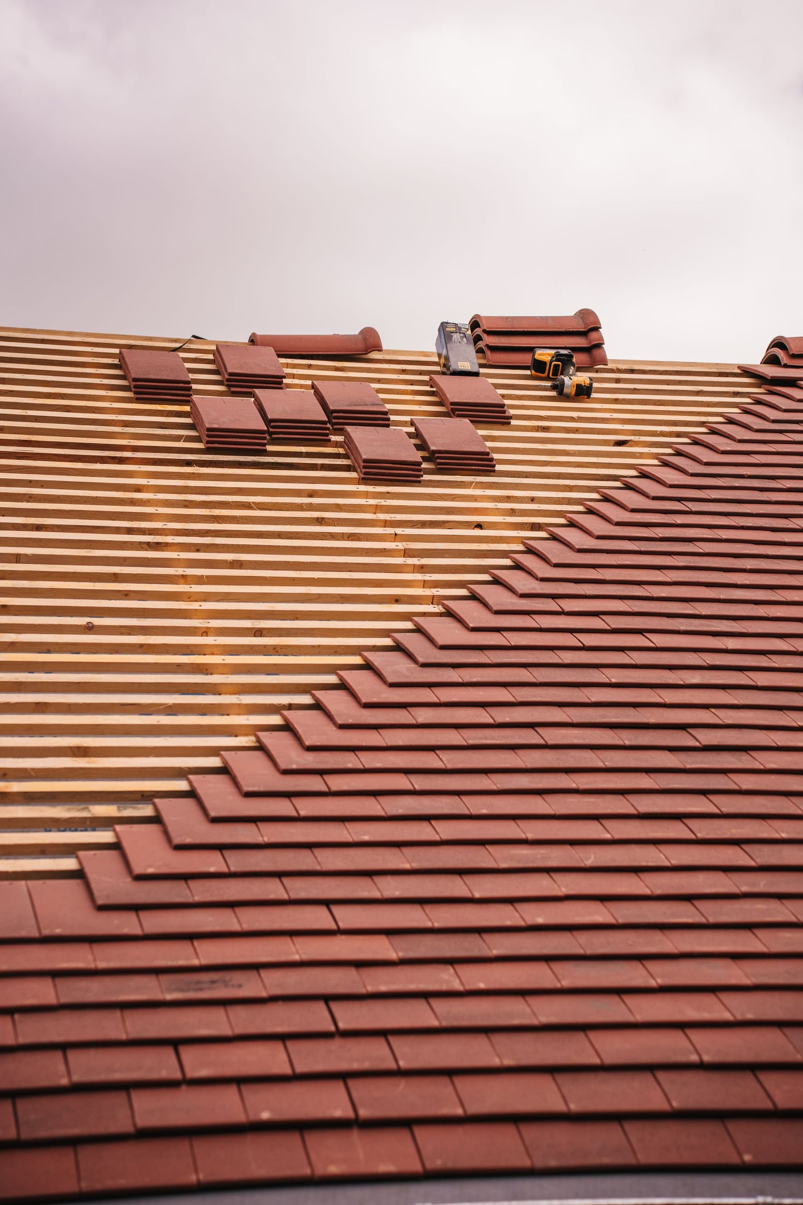 Tile roof installation showing underlayment beneath partially installed tiles